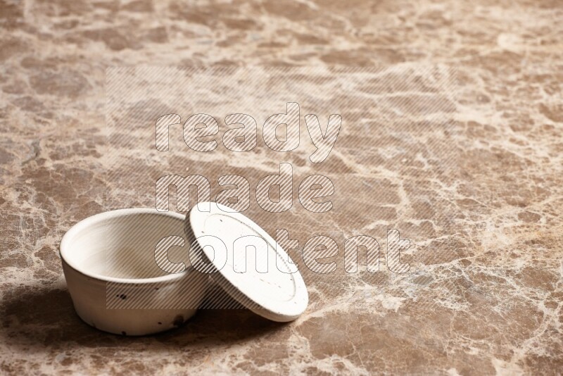 A white pottery bowl on beige marble background
