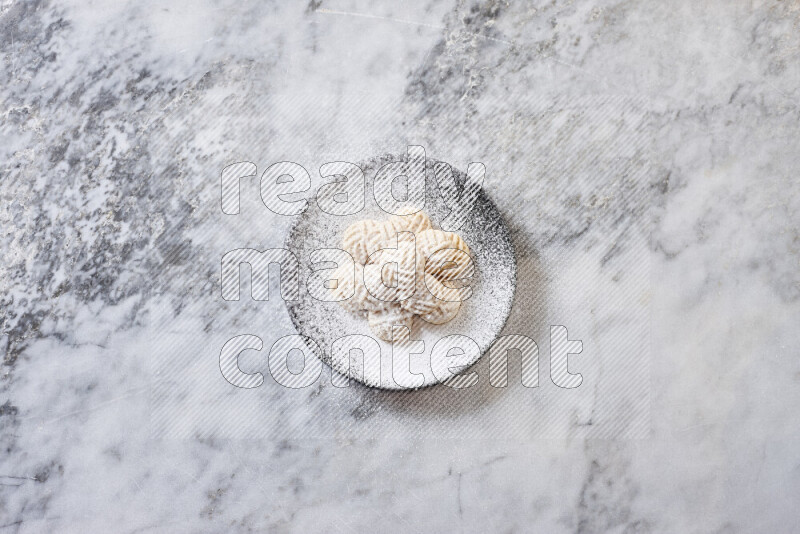 كحك في صحن فخار أسود على خلفية رخام رمادي