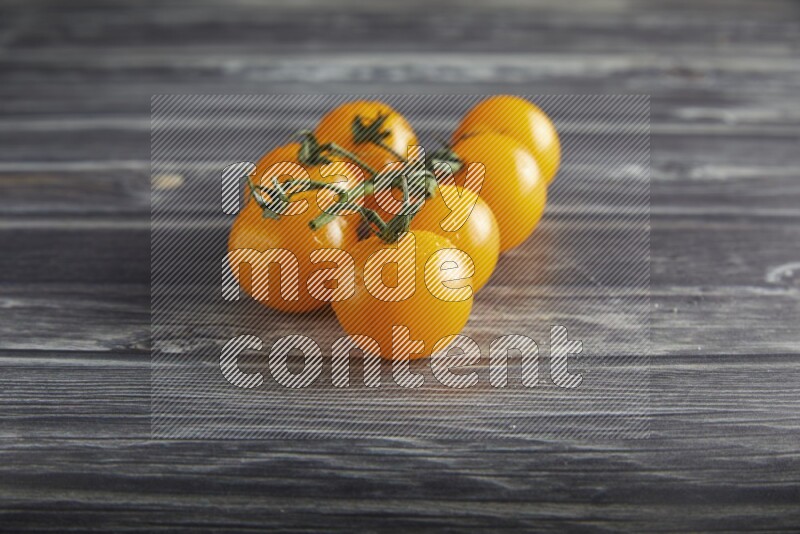 Yellow cherry tomato vein on a textured grey wooden background 45 degree