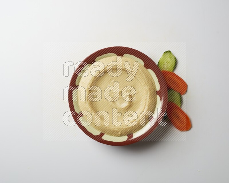Plain hummus in a traditional plate on a white background
