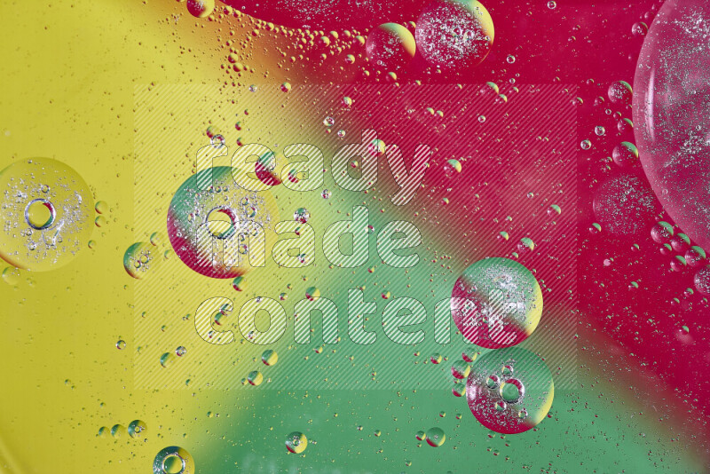 لقطات مقربة لفقاعات من الزيت على سطح الماء باللون الأصفر والأخضر والأحمر