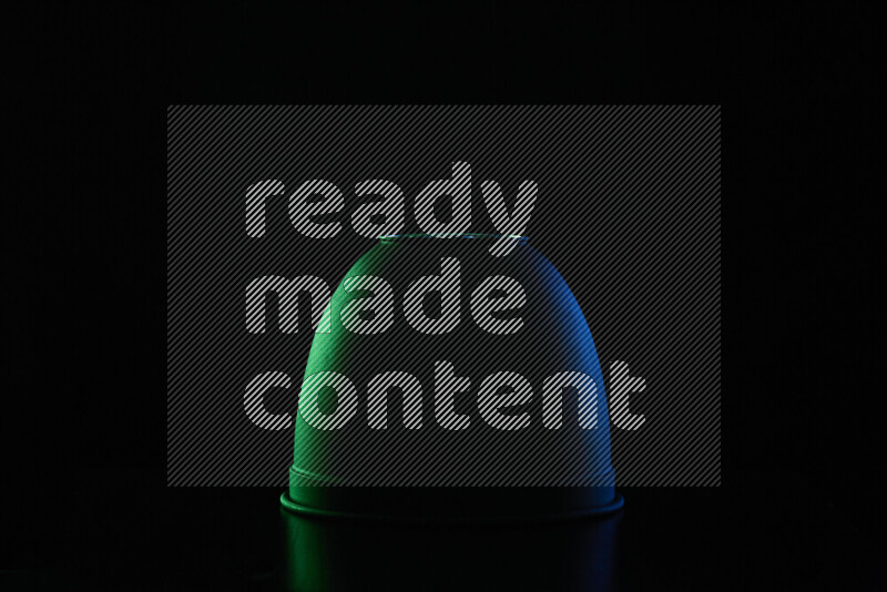 A reflector diffuser lamp shade dish with colored rim light against black background