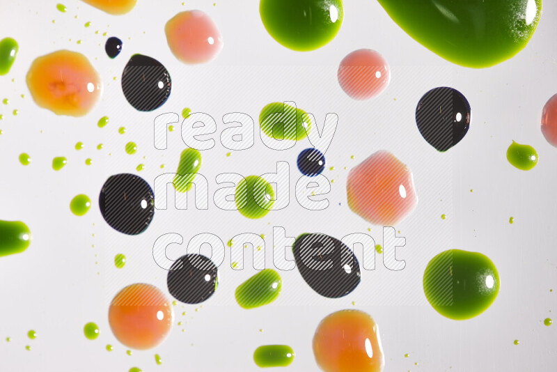 Close-ups of abstract green, blue and red paint droplets on the surface