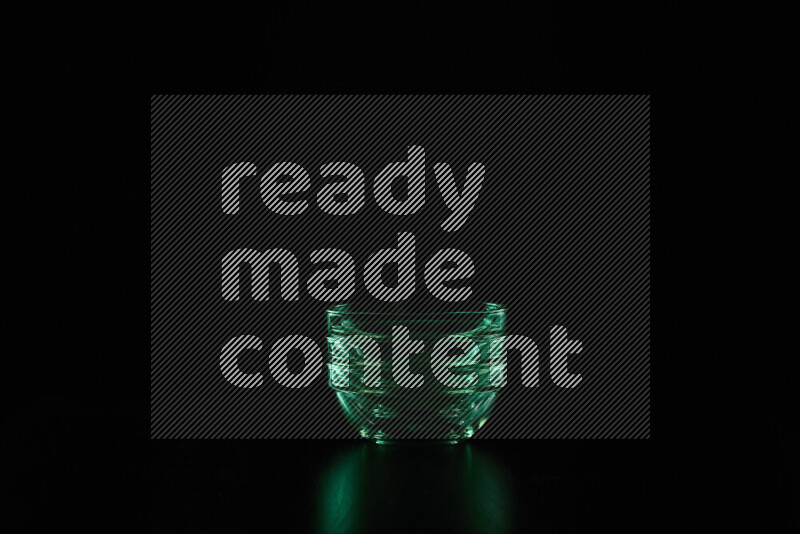 Glassware with rim light in green against black background