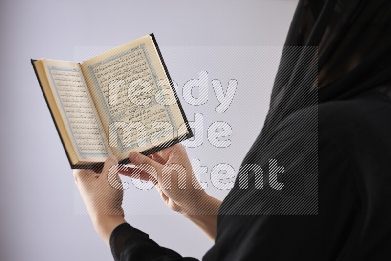 امرأة تحمل بيديها مصحف القرآن في أوضاع متعددة