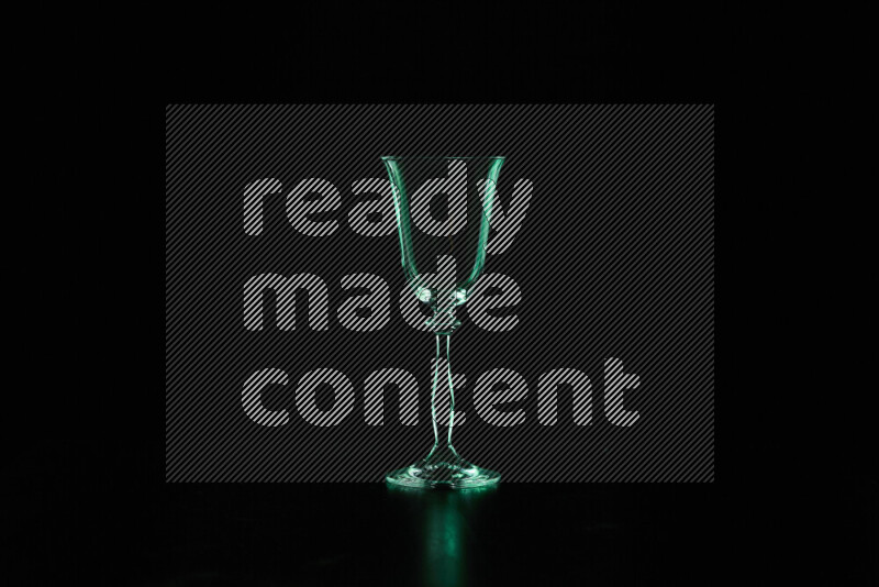 Glassware with rim light in green against black background