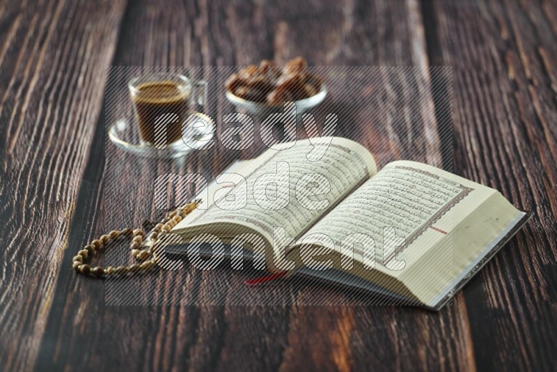 Quran with dates, prayer beads and different drinks all placed on wooden background