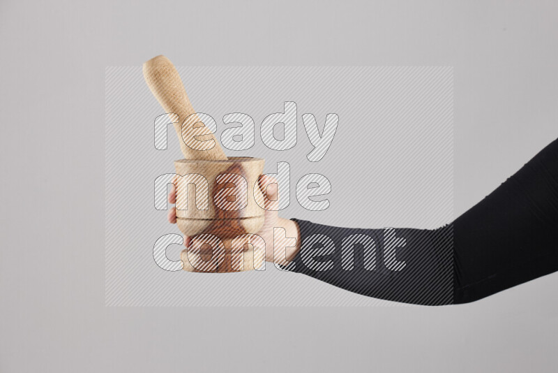 A woman in black abaya holding different wooden essentials in different positions