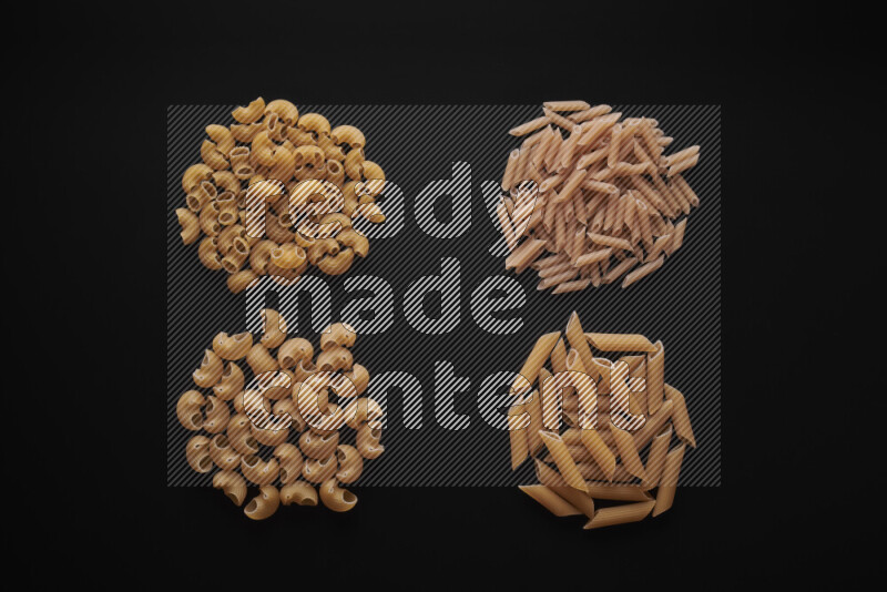 Different pasta types in bunches on black background