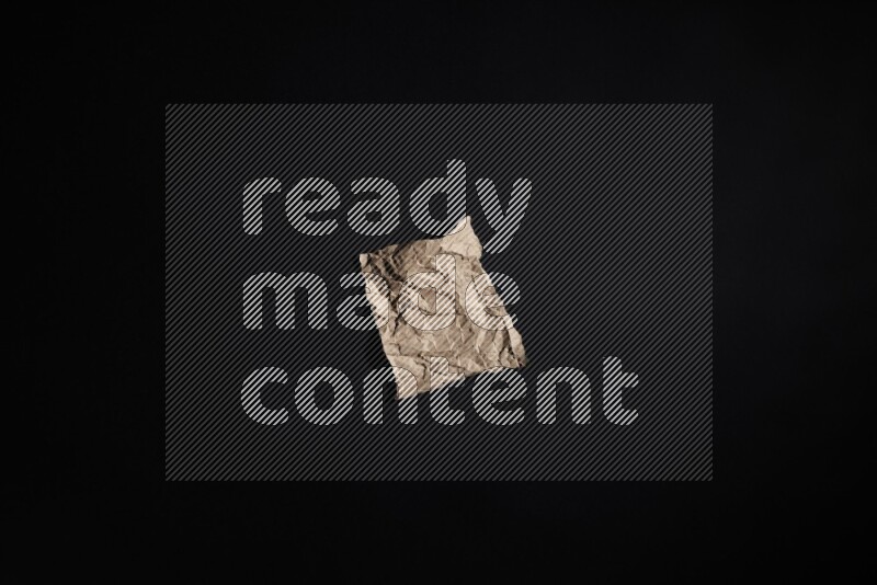 Crumpled craft paper on black background