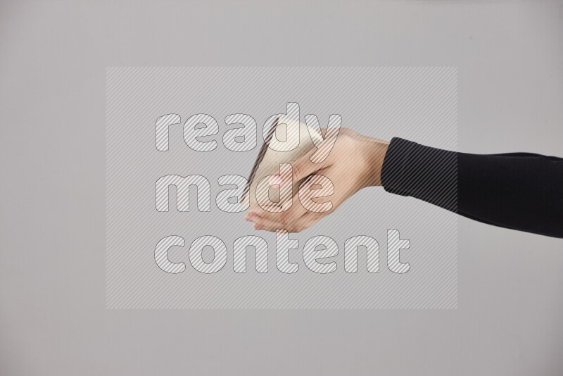 A woman in black abaya holding different pottery essentials in different positions