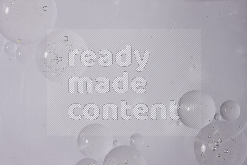 قطرات من الزيت على سطح الماء على خلفية بيضاء