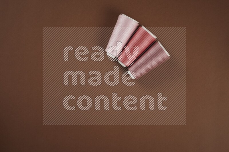 مجموعة من أدوات الخياطة والتفصيل زهرية اللون على خلفية بنية