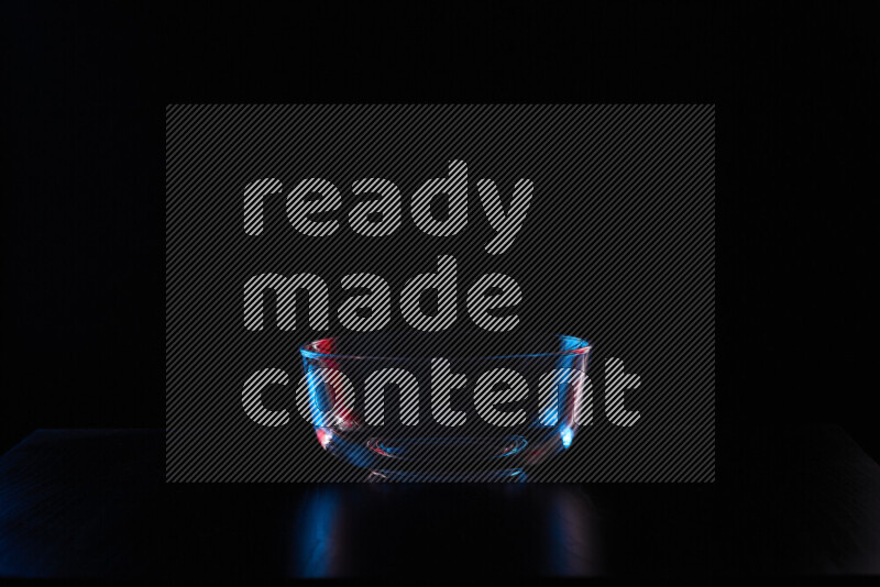 Glassware with rim light in red and blue against black background