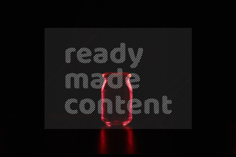 Glassware with rim light in red against black background