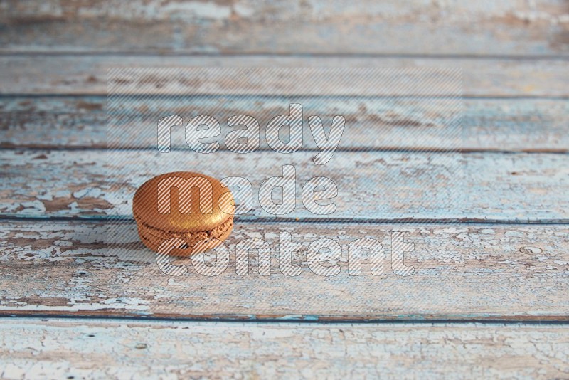45º Shot of Brown Coffee macaron on light blue wooden background
