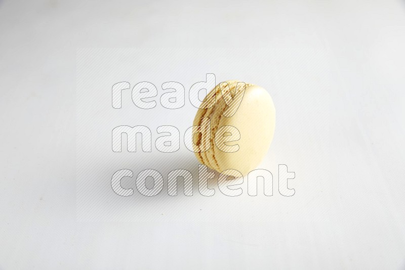 45º Shot of Yellow Vanilla macaron on white background