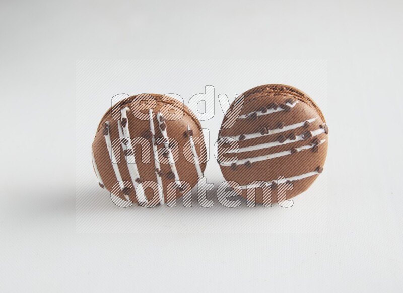 45º Shot of two Brown white Chocolate Caramel macarons on white background