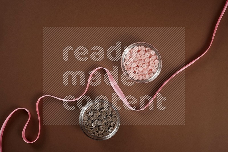 Pink sewing supplies on brown background