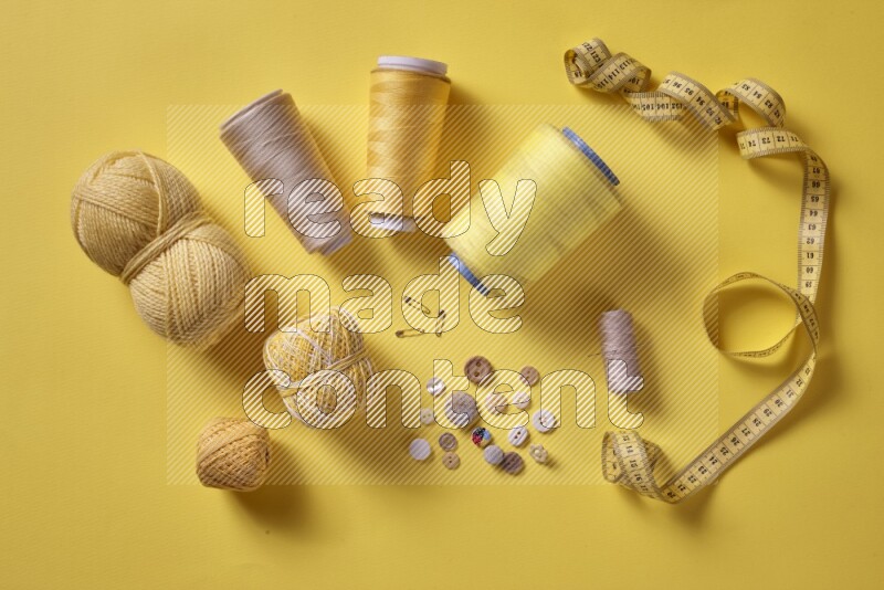A yellow collection of sewing and tailoring tools arranged on a yellow background