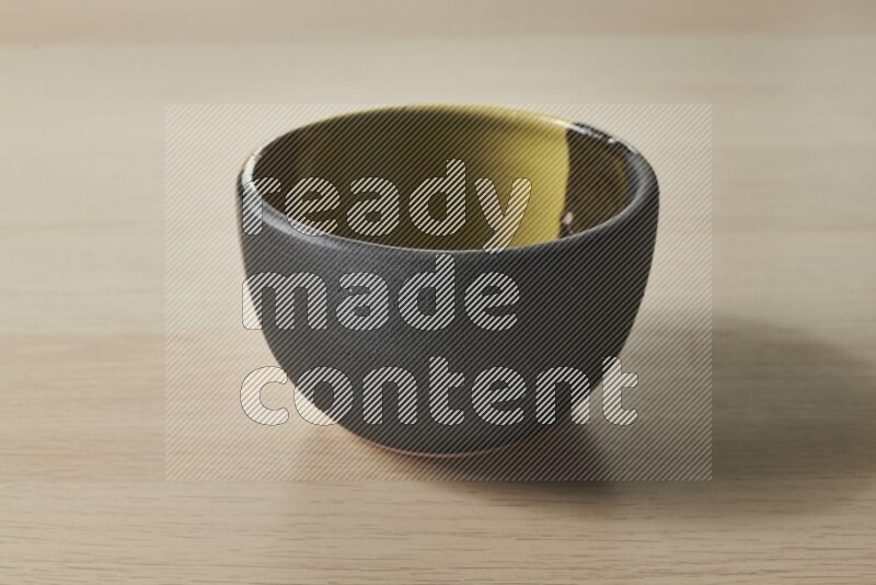 A multicolored pottery bowl on light wooden background