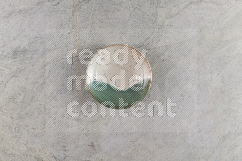 A decorative pottery plate on grey marble background