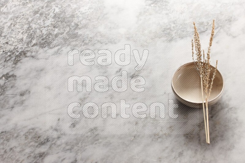 Wheat stalks on Beige Pottery Bowl on grey marble flooring, 45 degree angel