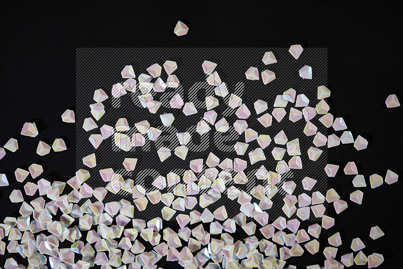 Colorful plastic shards for decoration scattered on a black background