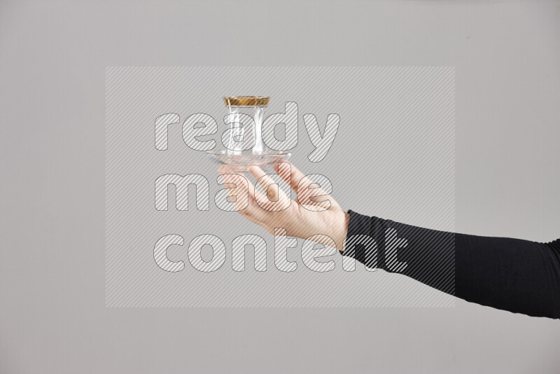 A woman in black abaya holding different glassware in different positions