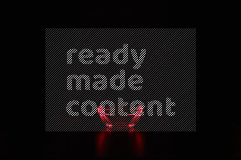 Glassware with rim light in red against black background