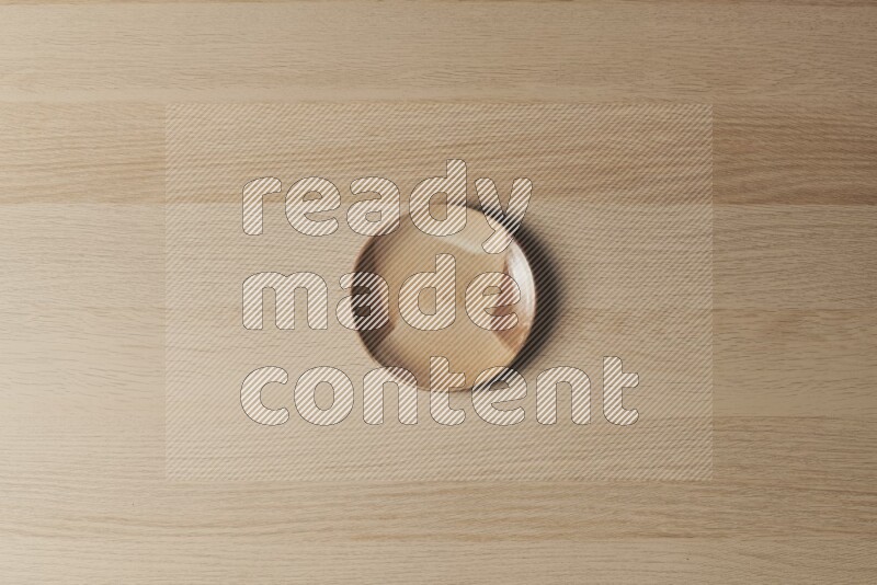 A multicolored pottery plate on light wooden background