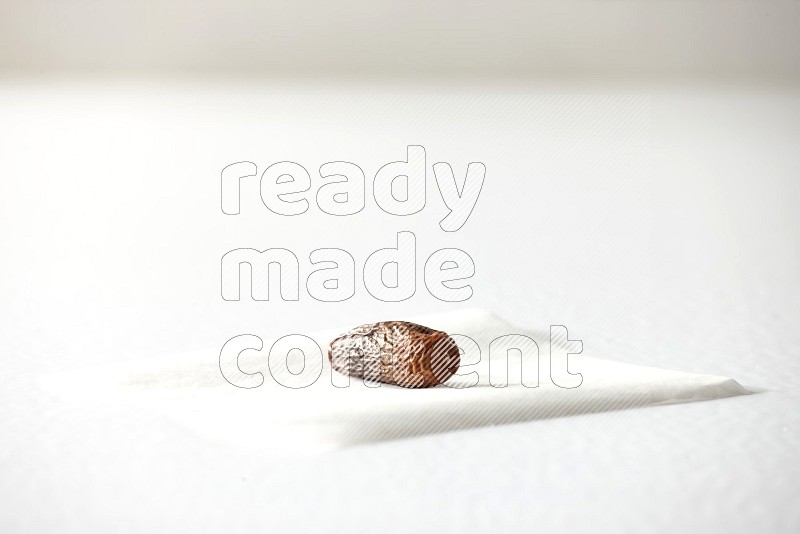 A dried date on a piece of paper on a white background in different angles