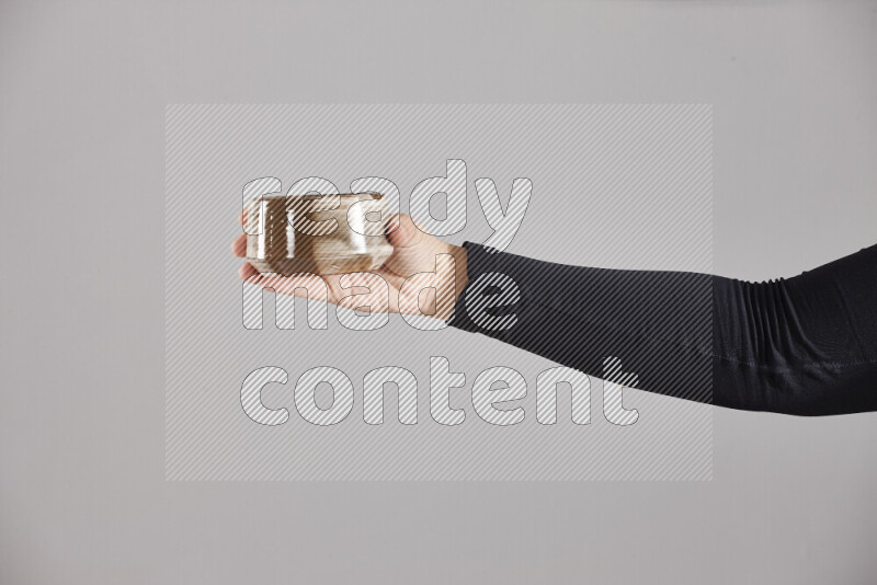 A woman in black abaya holding different pottery essentials in different positions