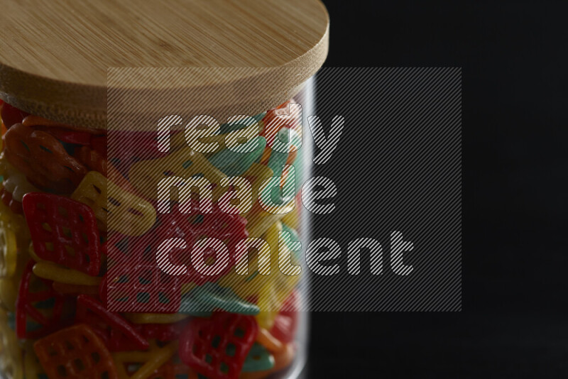 Snacks in a glass jar on black background
