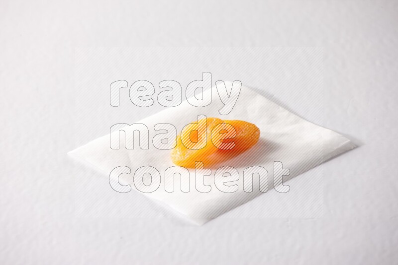 Two dried apricots on a piece of paper on a white background in different angles