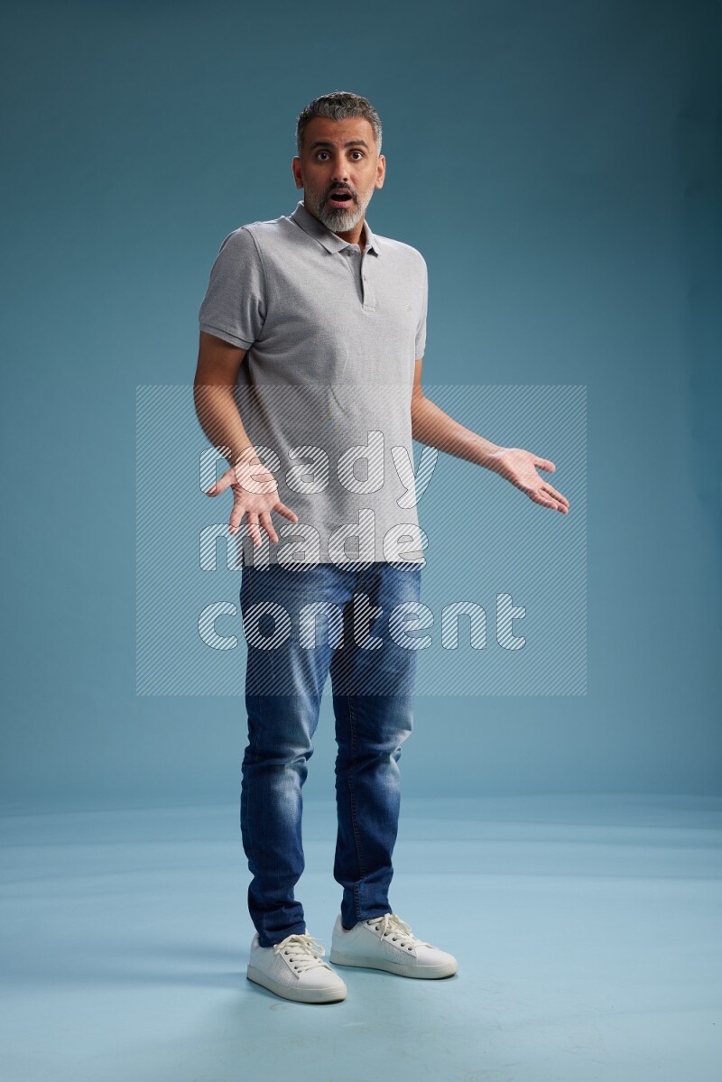 Man Standing Interacting with the camera on blue background