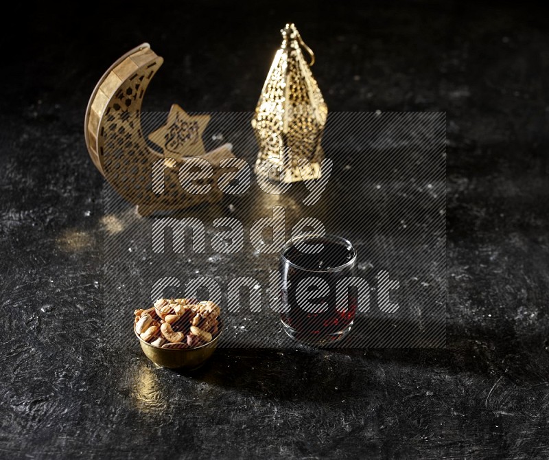 مكسرات في وعاء معدني مع مشروب التمر الهندي بجانب فوانيس ذهبية علي خلفية سوداء