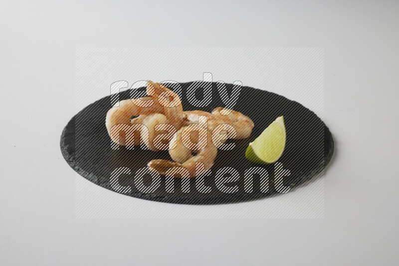 five grilled shrimps  on a black slate direct  on a white back ground