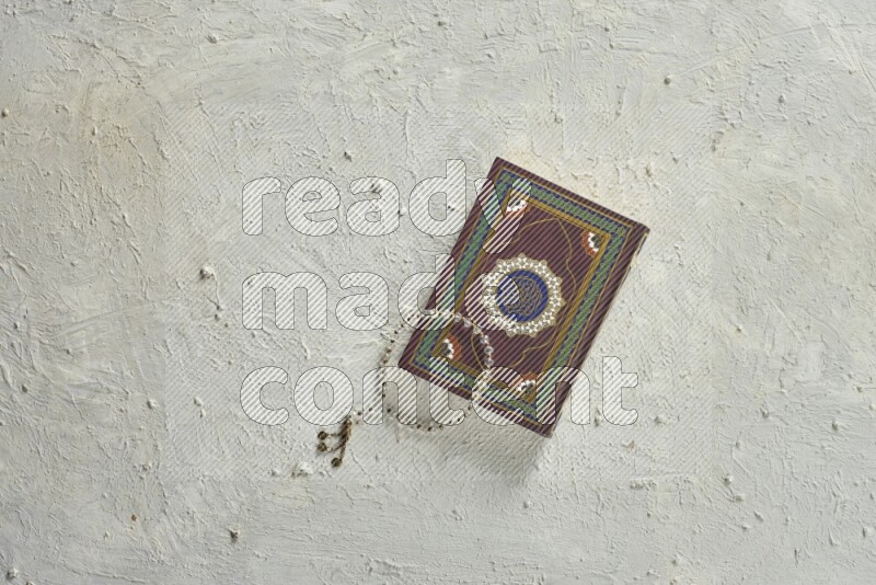 Quran with a prayer beads on white background