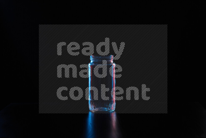 Glassware with rim light in red and blue against black background