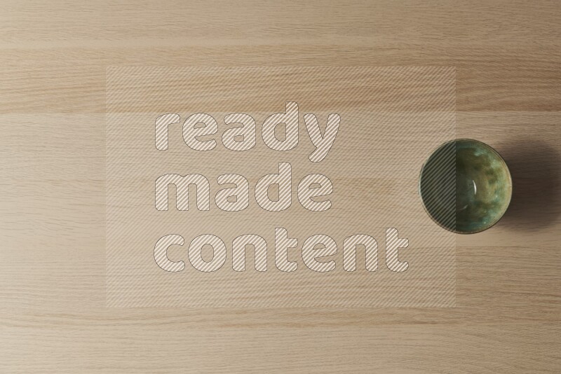 وعاء فخاري أخضر داكن على خلفية خشبية فاتحة