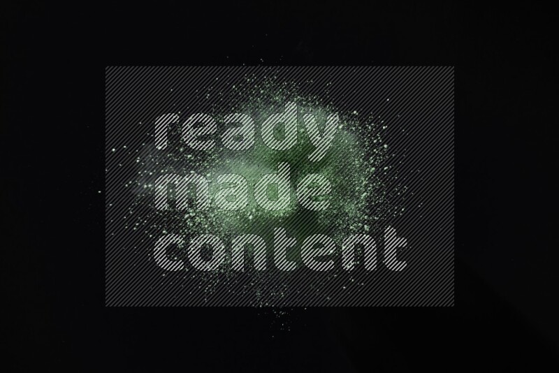 Green powder explosion on black background