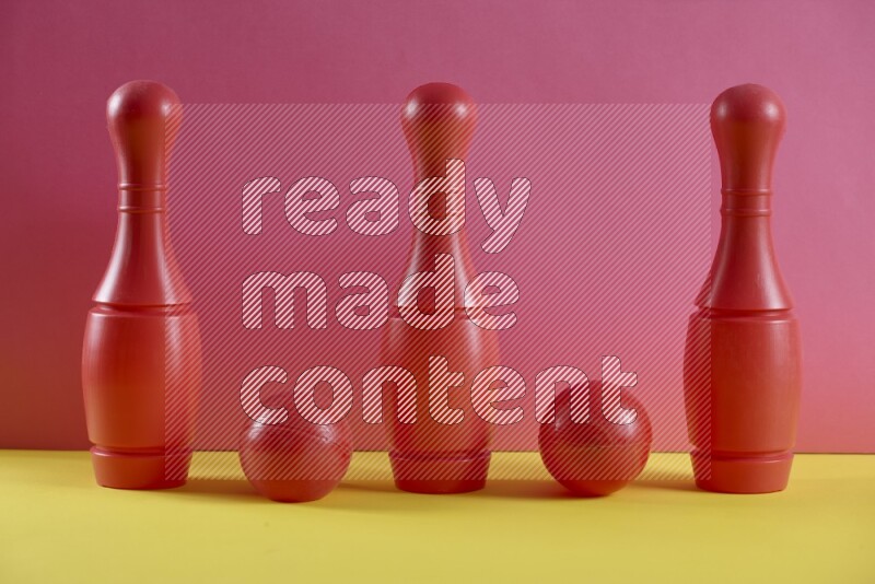 Plastic bowling pins with balls on pink and yellow background (kids toys)