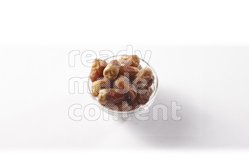 Dates in a glass bowl on white background