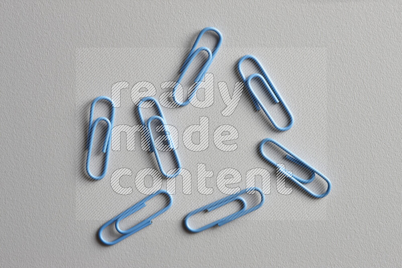 Blue paper clips isolated on a grey background