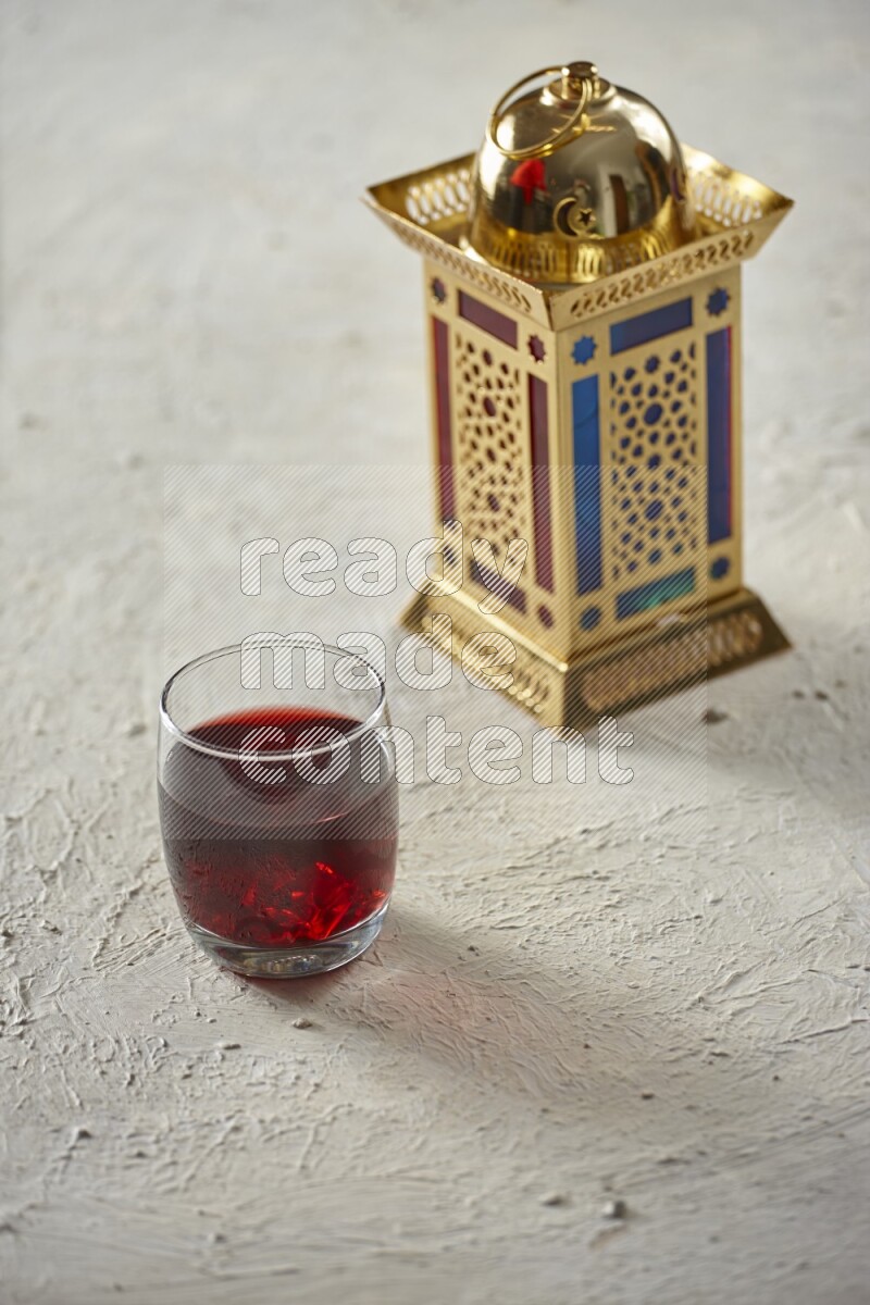 A golden lantern with different drinks, dates, nuts, prayer beads and quran on textured white background