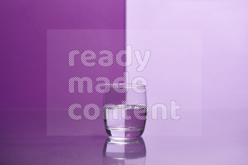 The image features a clear glassware filled with water, set against purple and light purple background