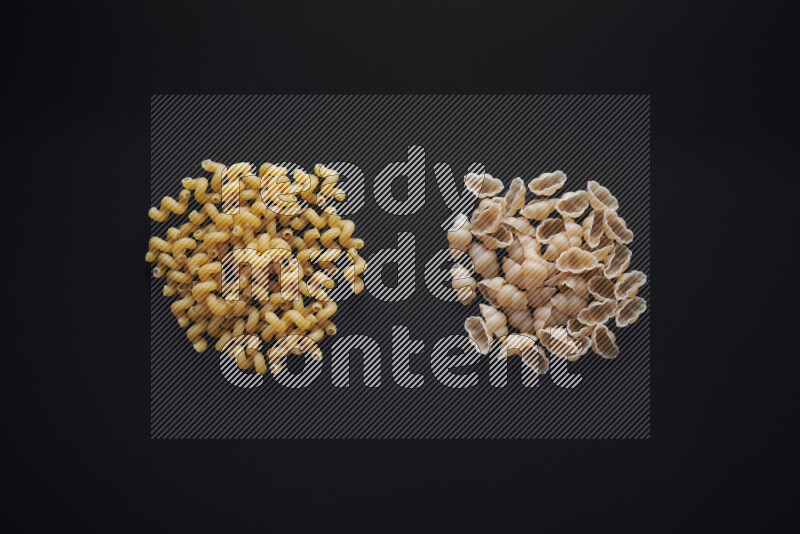 Different pasta types in bunches on black background