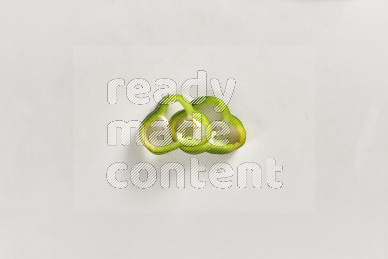 Green bell pepper slices on white background