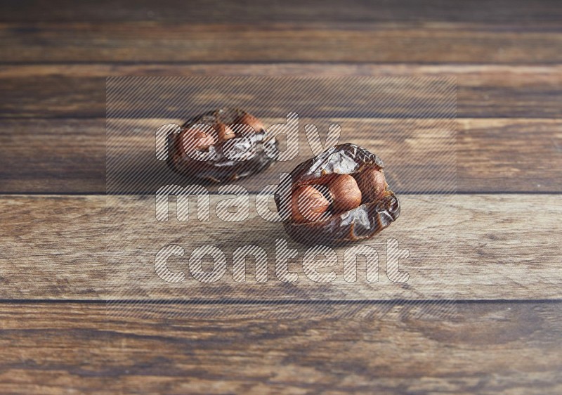 two hazelnut stuffed madjoul date on a wooden background